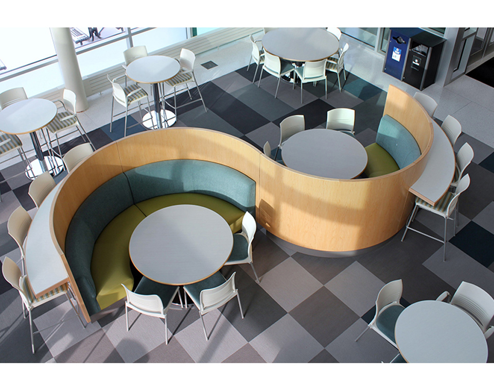 curved banquette seating with wood privacy panels and café tables