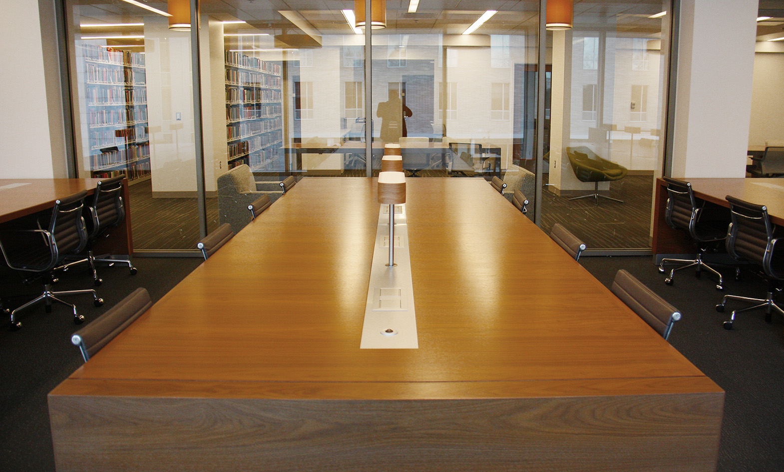 Custom library reading room table with integrated power and lamp in Law School