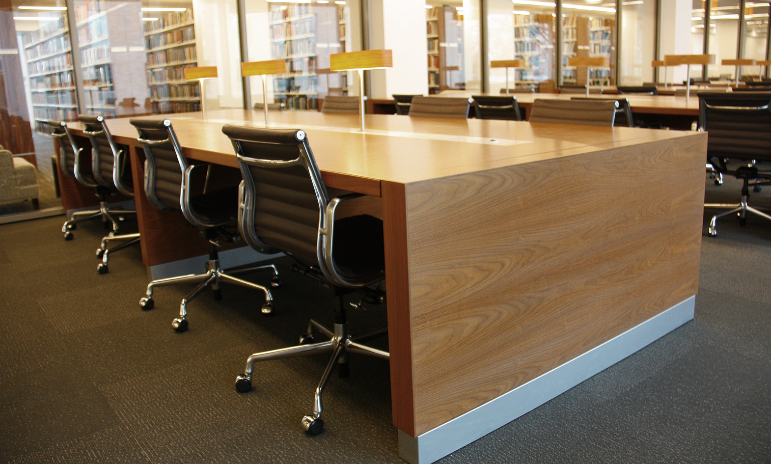 Custom library reading room tables with integrated power and lamp in Law School