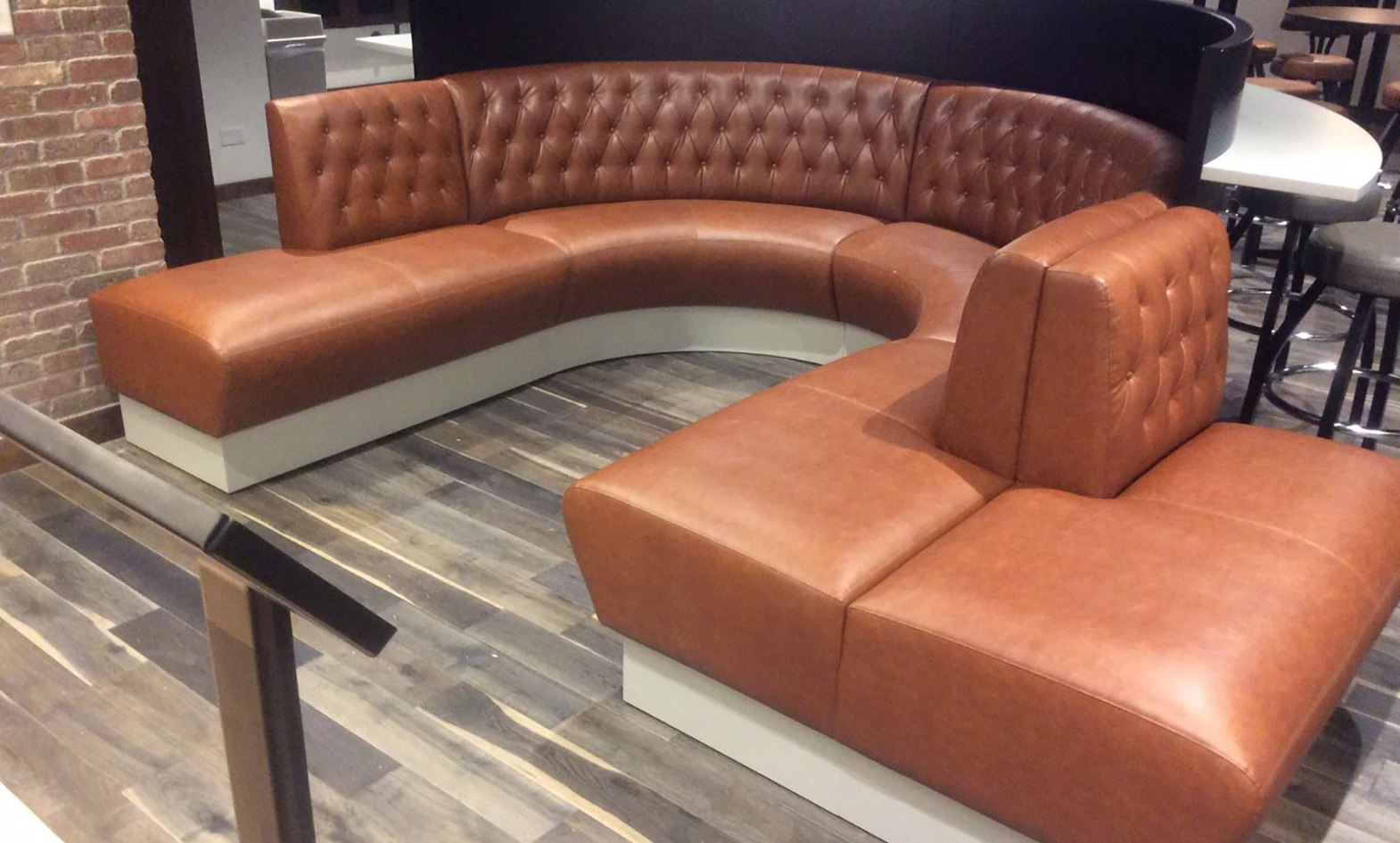 Custom curved banquette seating with bench, wood veneer privacy screen and cantilevered work surface for casino