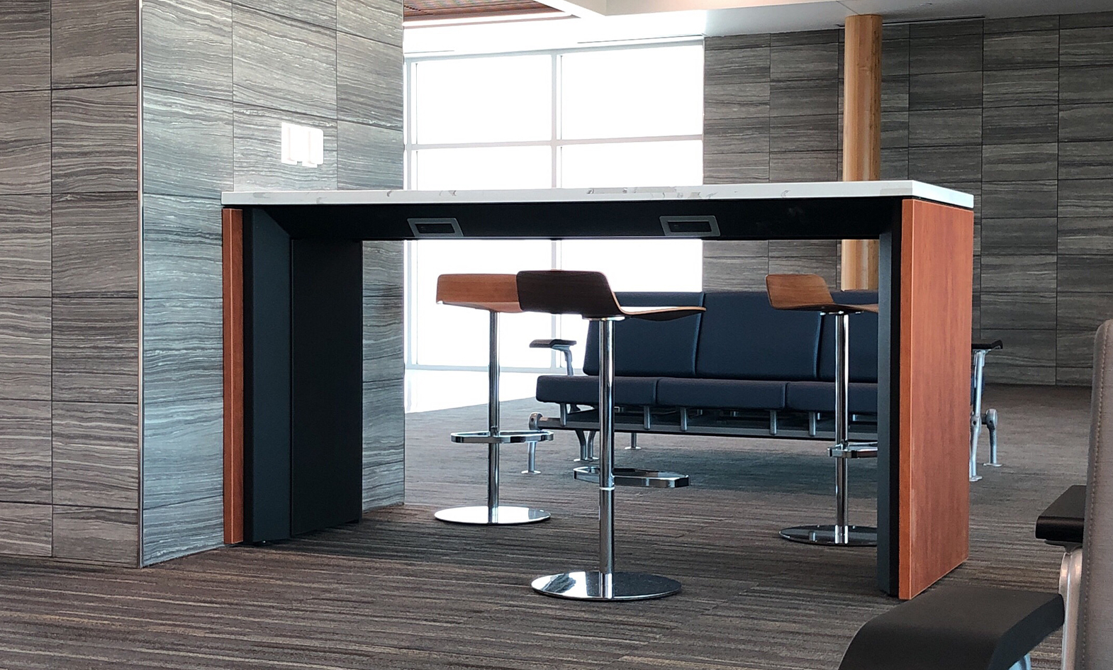 airport charging table with solid surface top and wood side panels at Airport Terminal