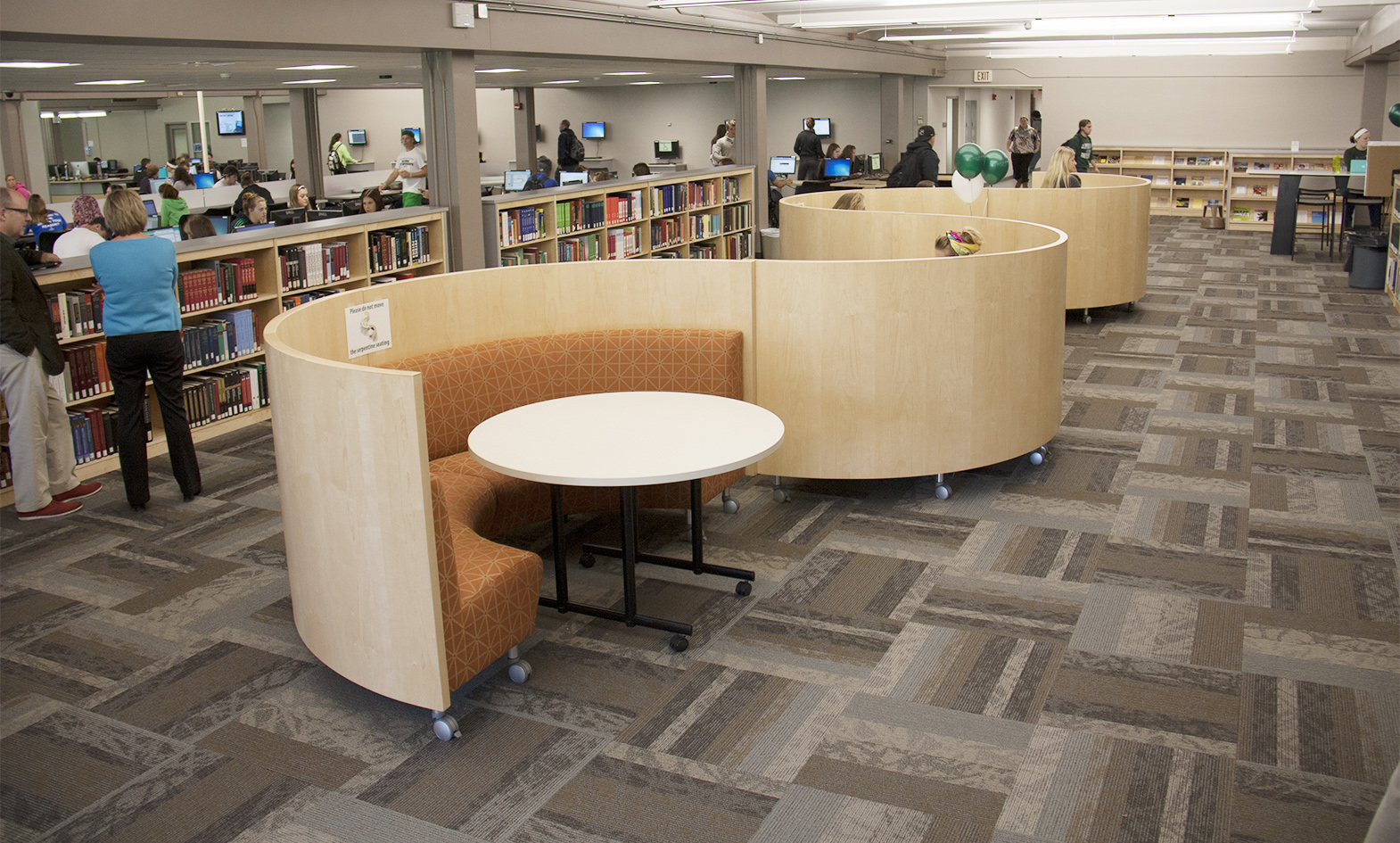 Curved banquette seating with wood privacy panels in serpentine design for collaboration at public library