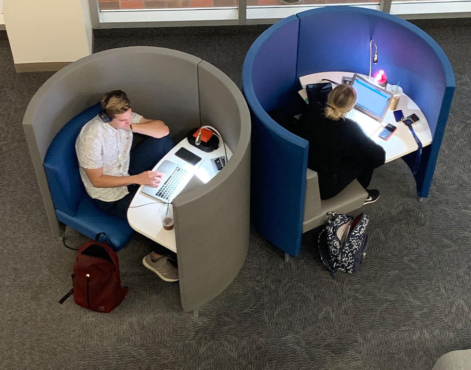University students studying in curved study carrel with access to power and task light