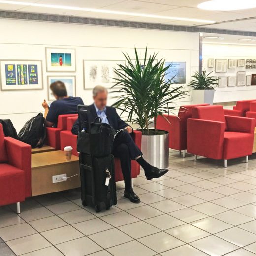travelers reading and recharging in airport terminal lounge seating