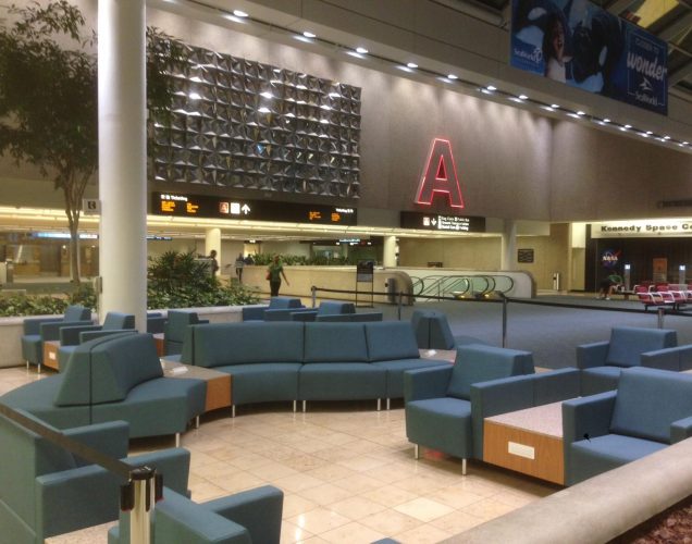 curved airport lounge seating, stone top tables and airport charging tables