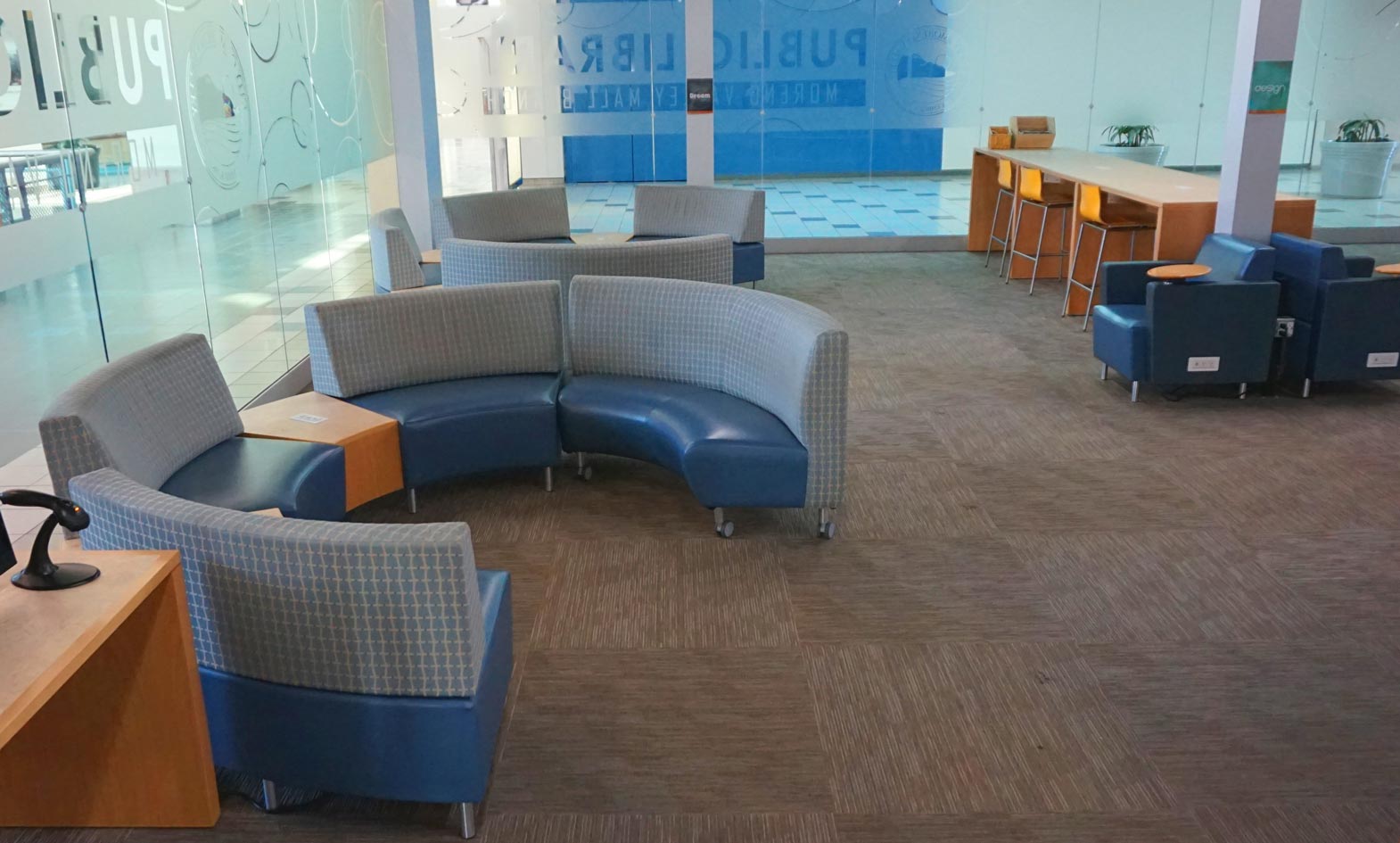 Public Library furniture with curved lounge seating, lounge chairs with tablet arms and large café height wood table