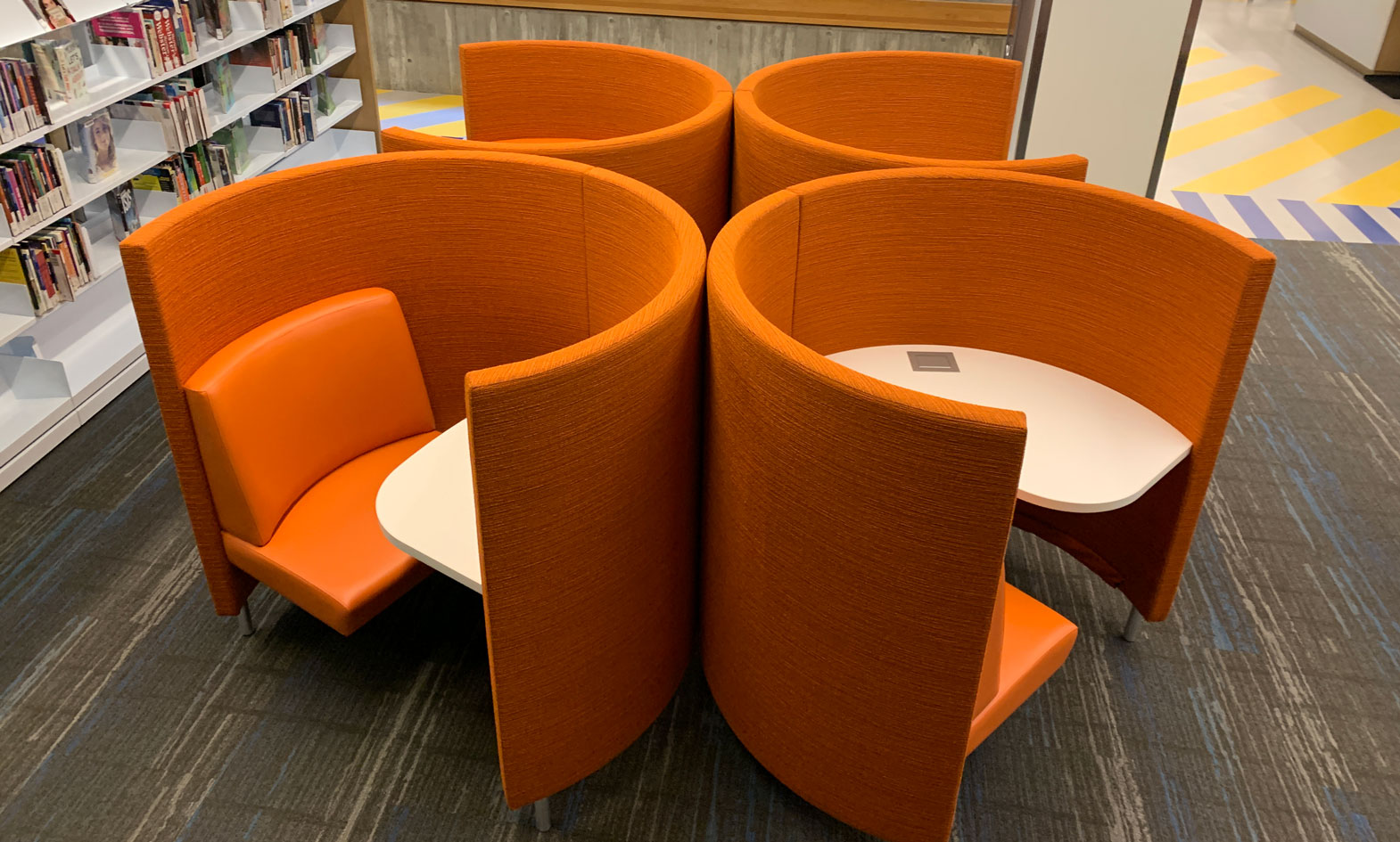 POD study carrels shown in vibrant orange with access to power in public library