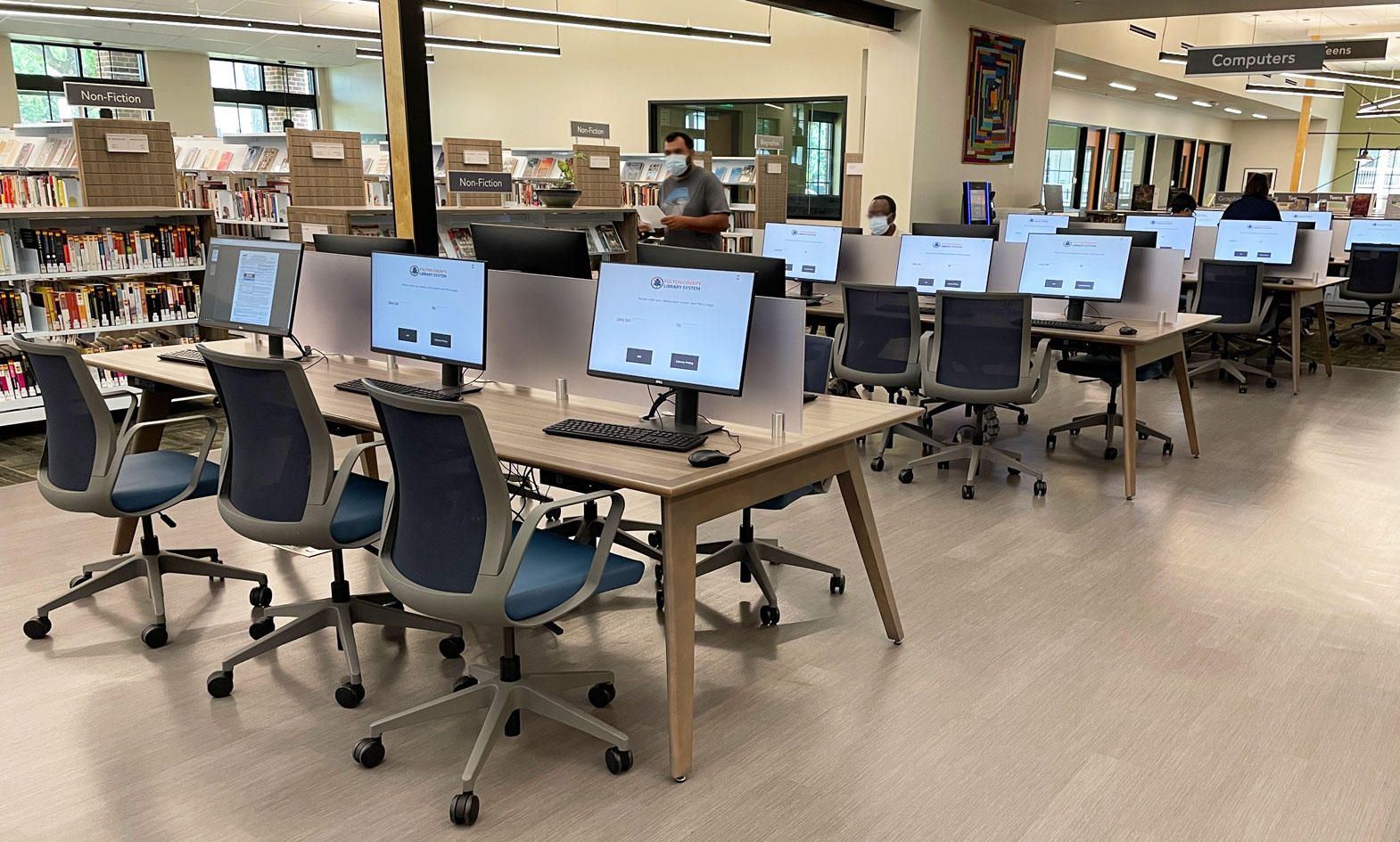 wood computer tables with integrated power, cable management and frosted center divider in public library