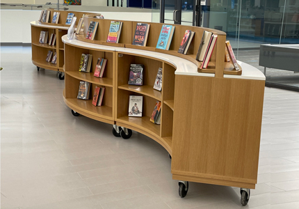 curved library shelving with book display on casters