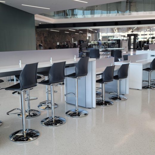 White airport charging table with solid surface tops and panels for passengers to charge devices
