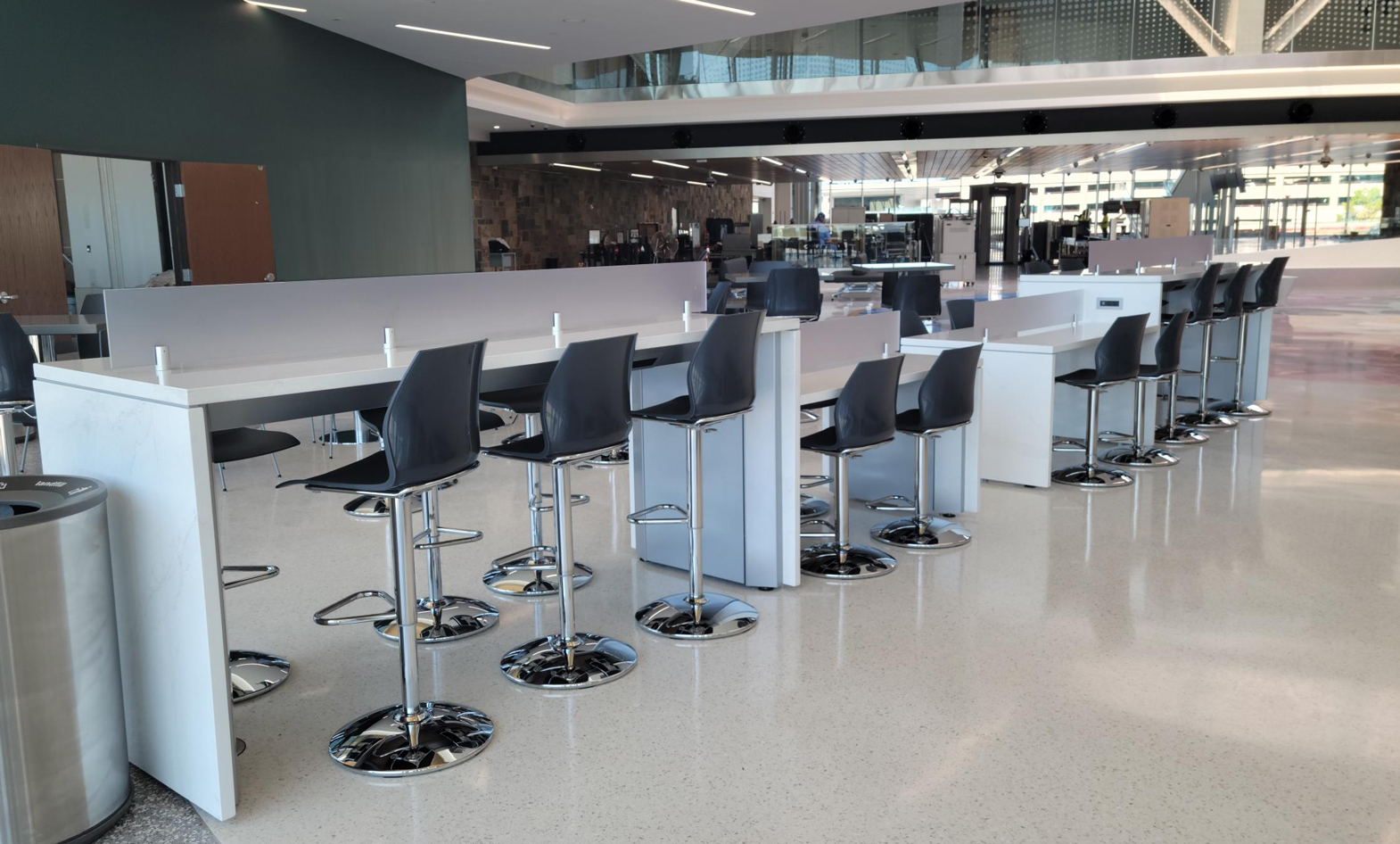 White airport charging table with solid surface tops and panels for passengers to charge devices