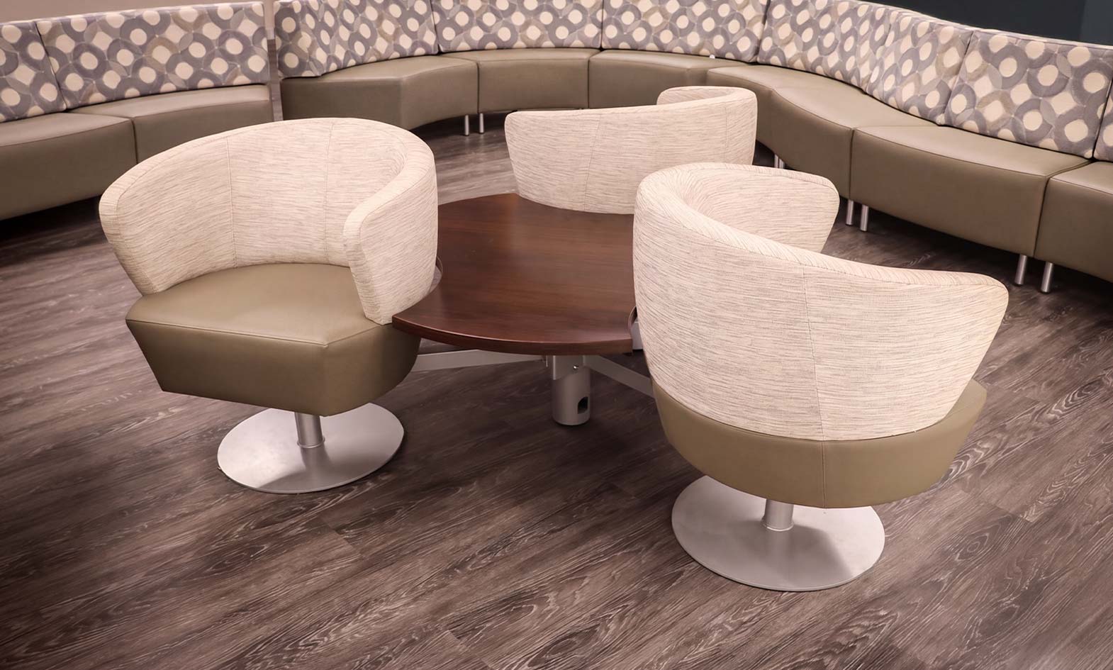 Three-chair Orb Lounge cluster with shared wood table, backed by curved modular lounge seating, Fort Wayne International Airport