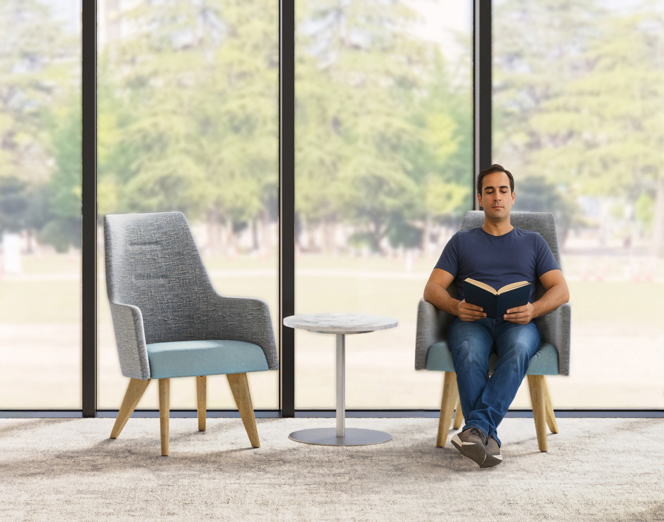 Man reading comfortably in high back armchair