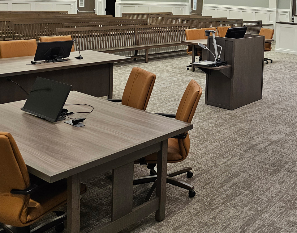 Podium, tables and benches in white county justice center courtroom