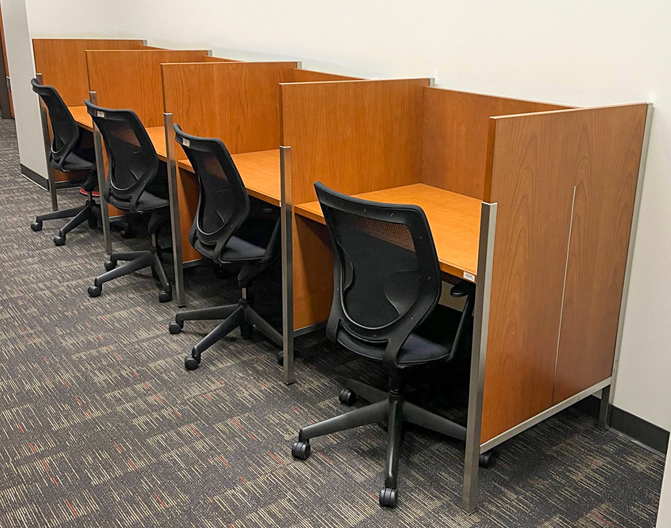 Single-facing Roland Carrels in lined against a wall in the USC Gould School of Law library, thin stainless steel legs visible.
