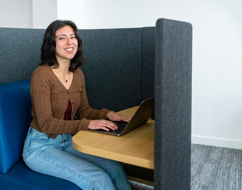 A student using an Agati study pod with a laptop in the MiraCosta College library
