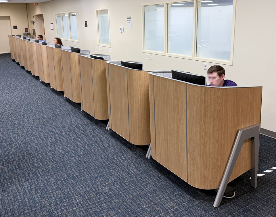 Students studying in a row of AGATI Cove Carrels with their backs toward the wall at UVA’s Claude Moore Library.