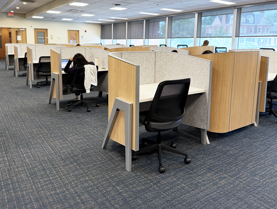 Wood-finish AGATI Cove Carrels with gray interior panels arranged near windows at UVA’s Claude Moore Library.